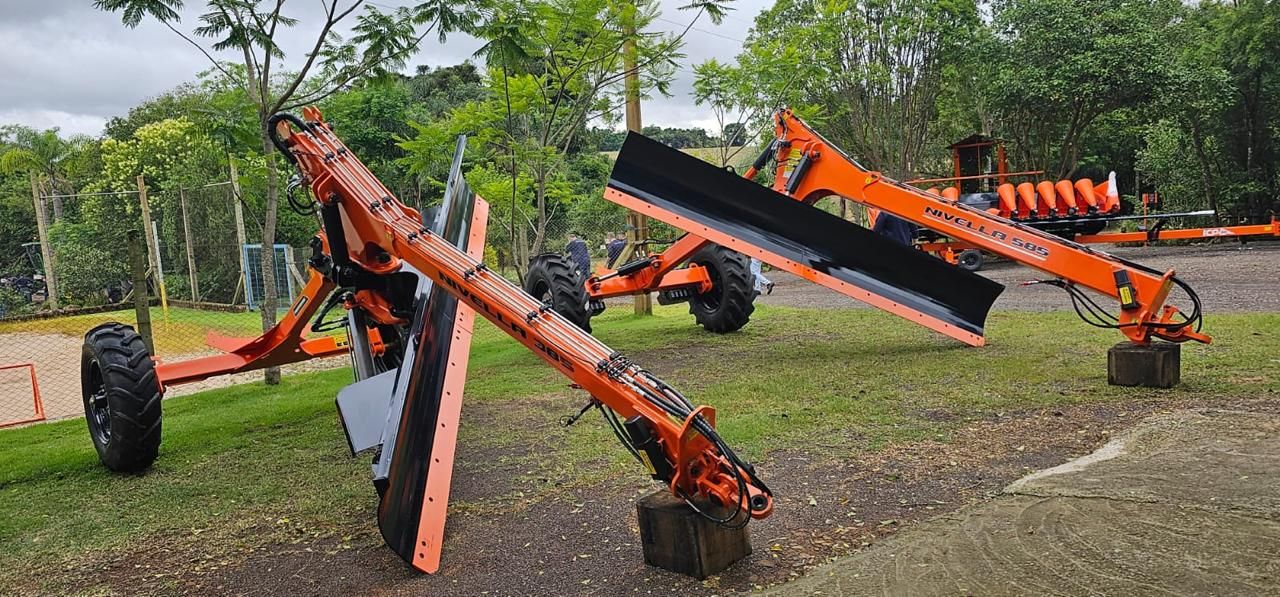 Implementos agrícolas vermelhos posicionados em área externa
