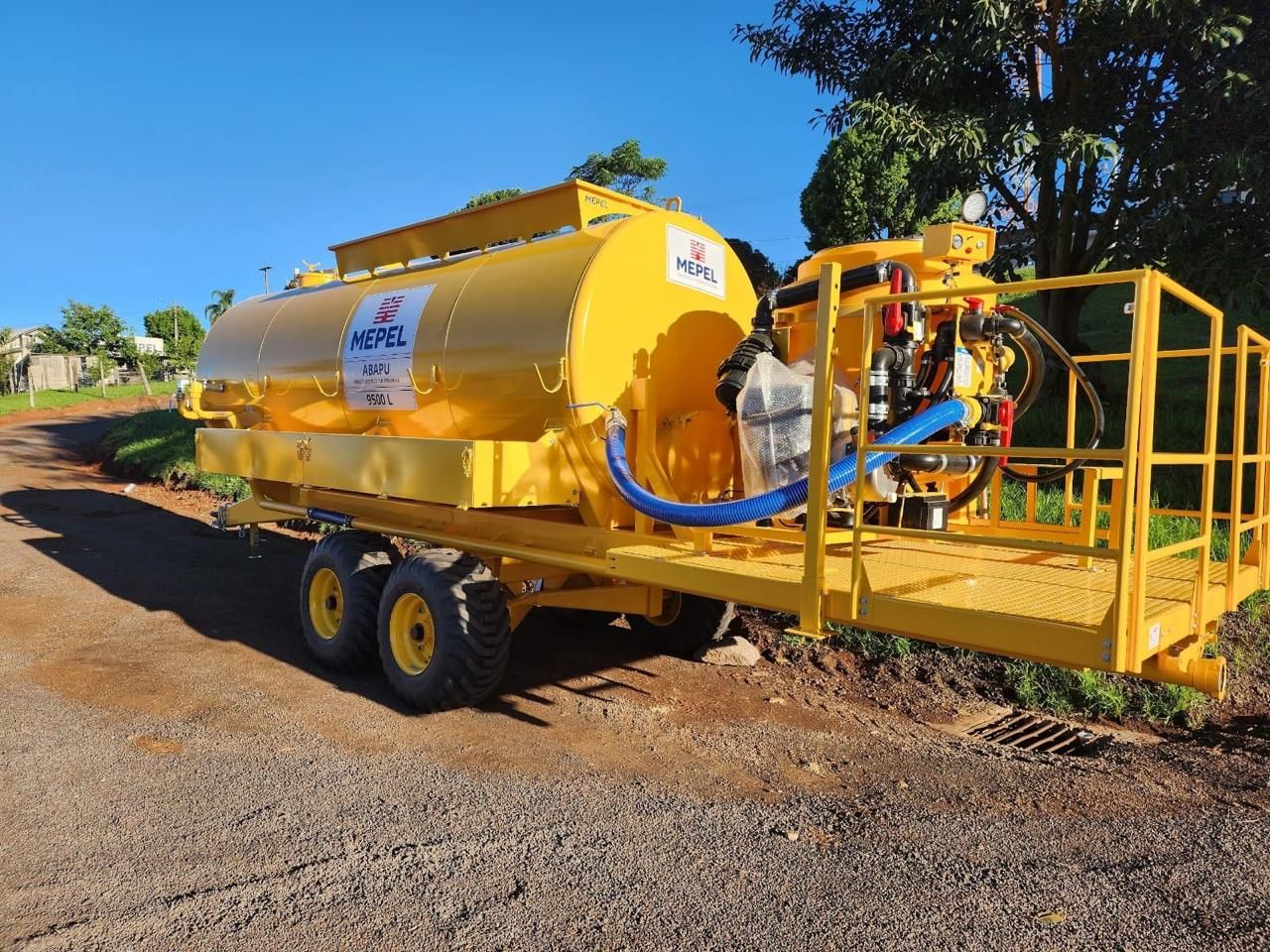 Tanque pipa amarelo rebocado com plataforma de acesso